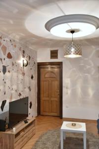 - un salon avec une télévision et une porte dans l'établissement Apartment Carpe diem in Belgrade, à Belgrade