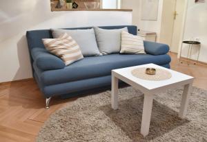 - un canapé bleu et une table basse blanche dans le salon dans l'établissement Apartment Carpe diem in Belgrade, à Belgrade