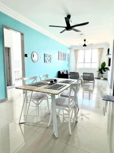 a dining room with a table and a ceiling fan at New Seaview Families Suite - Breezy Blue in Kuala Terengganu