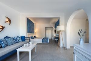 ein Wohnzimmer mit einem Sofa und einem Bett in der Unterkunft Rivari Santorini Hotel in Kamari