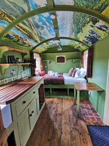 cocina y sala de estar con cama en una sala de tren en Stonehenge Inn & Shepherd's Huts en Amesbury