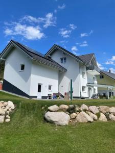 a white house with rocks in the yard at Ferienwohnung Seewaldstraße in Schluchsee