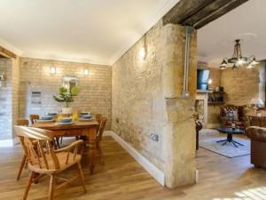 a kitchen and dining room with a stone wall at The Captains Nook-Hot tub in Amble