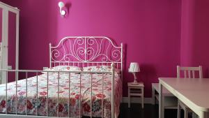 a purple bedroom with a bed and a table at The Green Lake House in Lenna