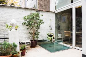 eine Terrasse mit einem Glastisch und Pflanzen in der Unterkunft Flagey Garden Residence in Brüssel
