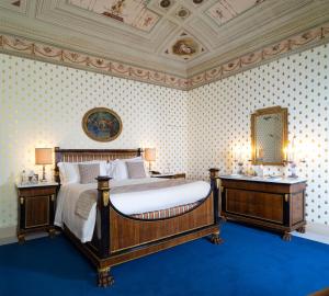 um quarto com uma cama grande e duas mesas de cabeceira em Villa Abbondanzi Resort em Faenza