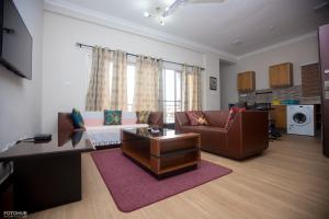 a living room with a couch and a table at Aviation Highway Apartment in Spintex