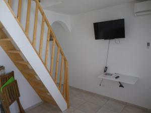 sala de estar con escalera y TV de pantalla plana en IMMEUBLE NEBOT en Grand-Bourg