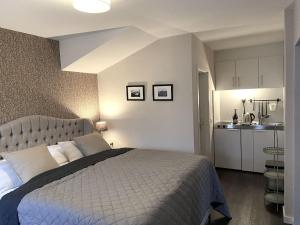 a bedroom with a large bed and a kitchen at GUNDT Amrum in Nebel