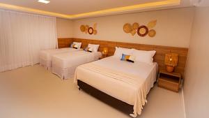 a bedroom with two beds and a lamp and mirrors at Paraiso Beach Hotel in Aquiraz +88 photos