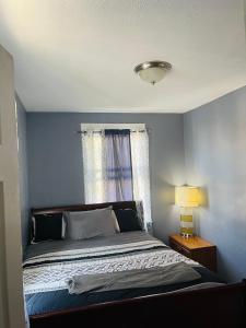 a bedroom with a bed with a blue wall at Royalbluecozy in Saint Albans