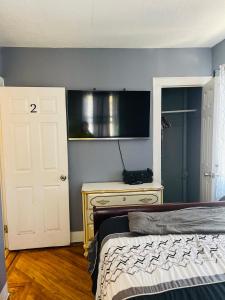 a bedroom with a bed and a television on a wall at Royalbluecozy in Saint Albans