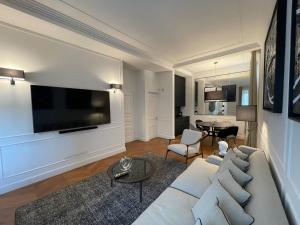 een woonkamer met een witte bank en een flatscreen-tv bij Calzaiuoli3 Luxury Flat in the City Center of Florence in Florence