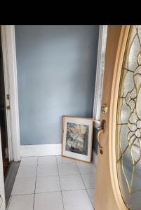 a door with a picture and a picture frame in a hallway at Royalbluecozy in Saint Albans