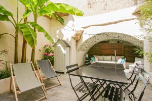 a patio with a table and chairs and a couch at La Maison Rose in Grignan