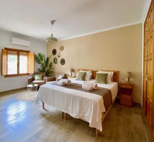 een slaapkamer met een groot bed en 2 handdoeken bij Casa de Los Lirios in Muro de Alcoy