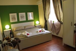 a room with a bed, a table and a lamp at Retrò Rooms in Cefalù