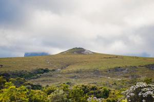a mountain on top of a grassy hill at Pousada Amanhecer in Vale do Capao