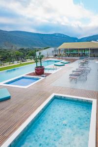 a pool with tables and chairs on a wooden deck at Pousada Amanhecer in Vale do Capao