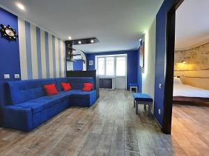 ポルタヴァにあるSea Style - Сеть апартаментов Alex Apartments Бесконтактное заселение 24-7の青いリビングルーム(青いソファ、ベッド付)