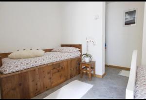 um quarto com uma cama de madeira e uma mesa em CASA CARCENTINA em Bormio