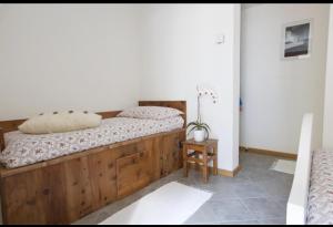 a bedroom with a wooden bed and a table at CASA CARCENTINA giardino, Pass zona rossa, Pista Olimpiadi Stelvio 2026 in Bormio