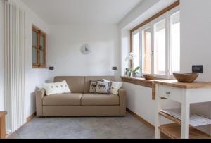 uma sala de estar com um sofá e uma janela em CASA CARCENTINA em Bormio
