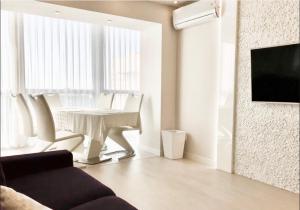 a living room with a white table and white chairs at Lux Most City area, panoramic river view, new tower in Dnipro