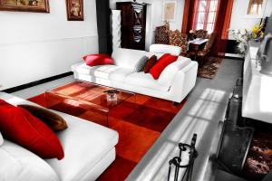 a living room with two white couches and red pillows at LE CHERCHE MIDI Chambres d'hôtes avec CUISINE EQUIPEE grand jardin PARKING SECURISE GRATUIT in Albi