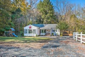 a white house with a fence and a playground at Peaceful Renovated Home with Deck on Half Acre! in Asheboro
