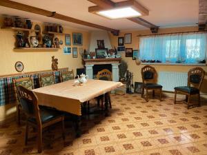 a dining room with a table and chairs and a fireplace at Вілла де Кампо in Chynadiyovo