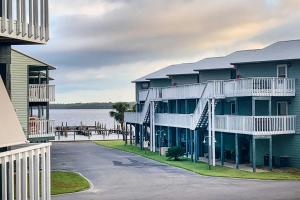 a large apartment building with a parking lot next to the water at Orange Beach Condo Private Boat Dock and Ramp in Orange Beach