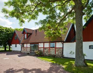 a red and white building with a tree at Torsborgs Gård in Simrishamn
