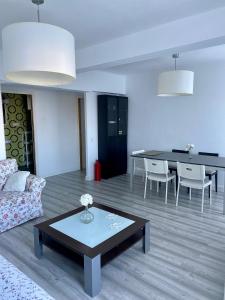 een woonkamer met een bank en een tafel bij 1 linea de playa poniente, puerto deportivo recien reformado in Gijón