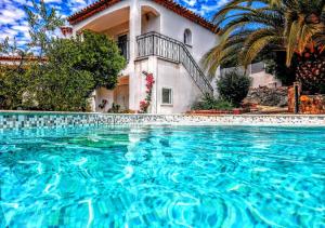 a large swimming pool in front of a house at Maxima Sunset in Sainte-Maxime