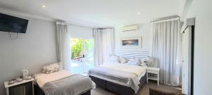 1 dormitorio con 2 camas y ventana en Finchley Guesthouse, en Ciudad del Cabo