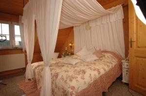 テットナングにあるLandhotel Gutshof Camping Badhüttenのベッドルーム(天蓋付きベッド1台付)