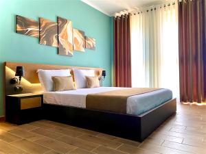 1 dormitorio con 1 cama grande y paredes azules en Eka Luxury Beachfront One-Bedroom Apartment, en Vlorë