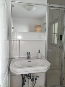 a bathroom with a white sink and a shower at Davosblick in Davos +20 photos