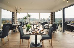 a dining room with tables and chairs and large windows at das MEISTER in Riegersburg