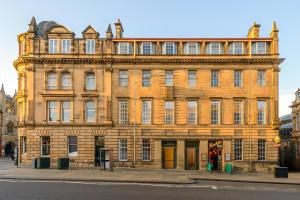 a large building with a clock on the front of it at Museum Apartments in Edinburgh
