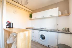 een keuken met een wastafel en een wasmachine bij Appartement 4 personnes 3 chambres tout confort in Bonsecours