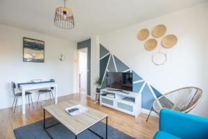 een woonkamer met een blauwe bank en een tafel bij Appartement 4 personnes 3 chambres tout confort in Bonsecours
