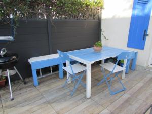a blue table and chairs with a potted plant on it at Fisherman's cottage in Ile d'Arz +12 photos