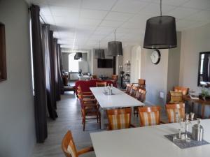 Jöhstadt的住宿－Die Alte Bäckerei，用餐室配有白色的桌子和木椅