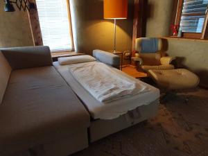 ein Schlafzimmer mit einem Bett, einem Stuhl und einer Lampe in der Unterkunft Halmhaus in Glees