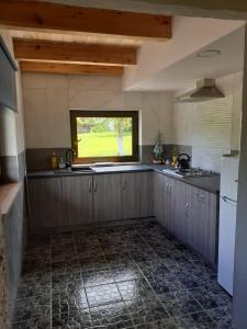 a kitchen with a sink and a window at zajęcza chata in Dolistowo