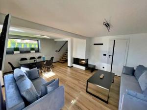 a living room with a blue couch and a fireplace at Dream House in Gdów