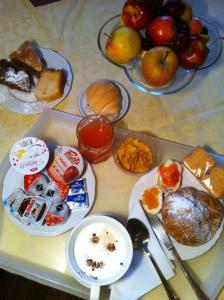 una mesa cubierta con platos de comida y tazones de fruta en Liberty Bed & Breakfast, en Verona