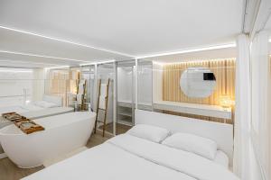 a room with four beds and a bath tub and a mirror at White Fox - sauna - in Lviv